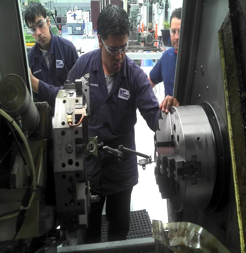 Equipo técnico de Numeric Control trabajando en un torno CNC